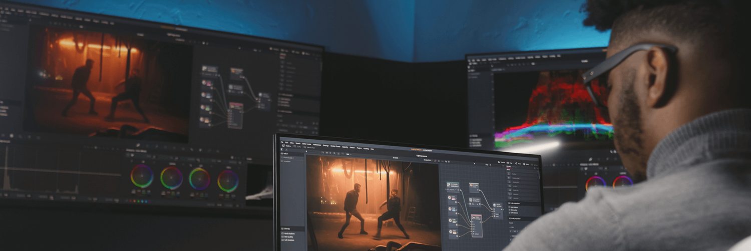Colourist reviewing footage and colour scopes across multiple monitors during professional video colour grading